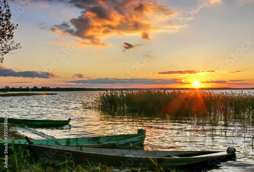 Fototapeta Naklejka Na Ścianę i Meble -  wooden boats near the shore at sunset