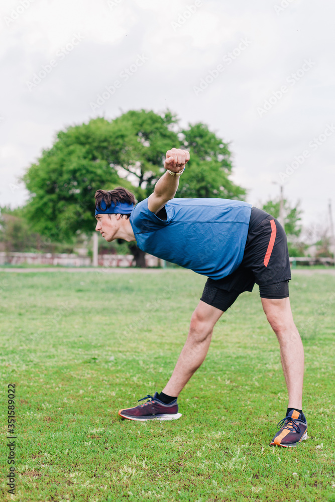 Obraz premium Athlete does warm-up before running at stadium