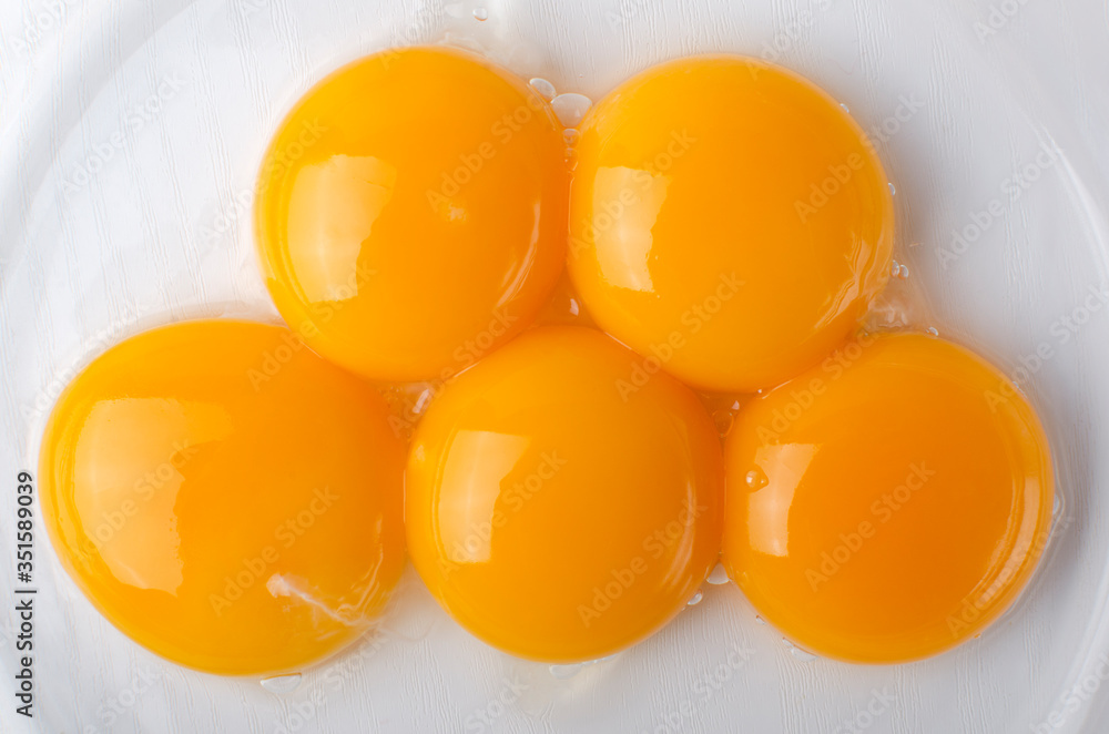 Top view and closeup of five separated yolk eggs in the bowl as a background Top view and closeup of five separated yolk eggs in the bowl as a background