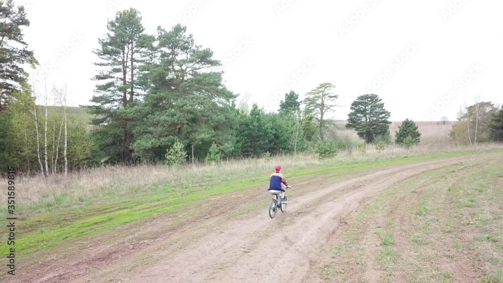 A boy is cycling in a field A boy is cycling in a field