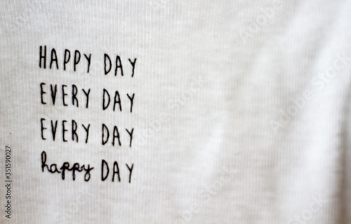 Close-up of white shirt saying "happy day every day"