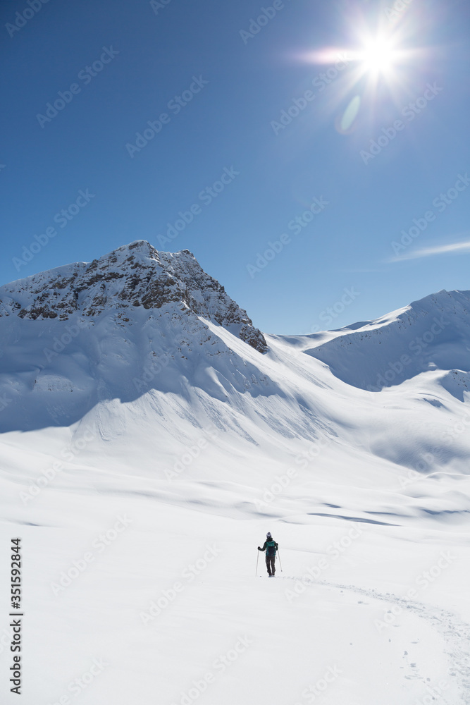 one women snowshoeing towards Valbellhorn mountain in winter landscape