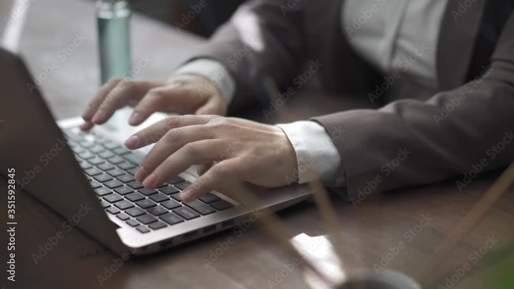 Businesswoman working on laptop computer sitting at the table in the modern office wearing business clothing. A woman fills the room with incense aromatherapy aroma sticks. Businesswoman working on laptop computer sitting at the table in the modern office wearing business clothing. A woman fills the room with incense aromatherapy aroma sticks.