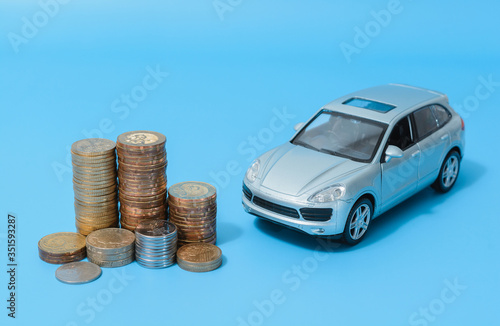 Stack of coins and an automobile.