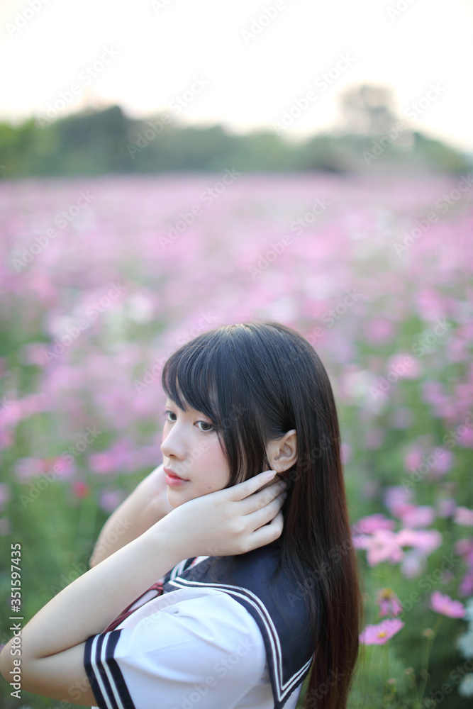 Portrait of Japanese school girl uniform with pink cosmos flower Portrait of Japanese school girl uniform with pink cosmos flower