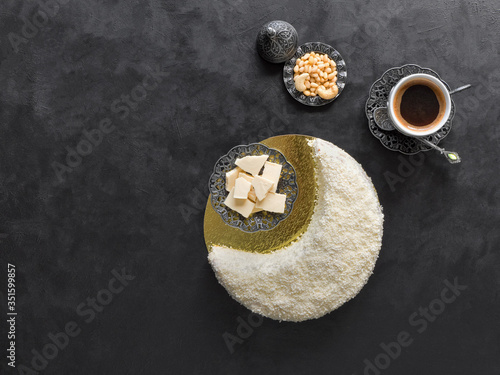 Festive food Ramadan background. Delicious homemade cake in the shape of a Crescent moon, served with dates and coffee cup