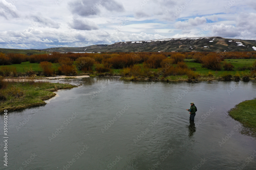 a high resolution aerial shot of a man fly fishing a high resolution aerial shot of a man fly fishing