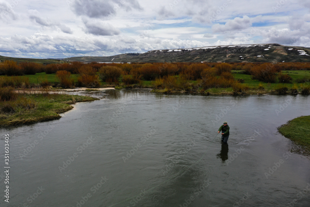 a high resolution aerial shot of a man fly fishing a high resolution aerial shot of a man fly fishing