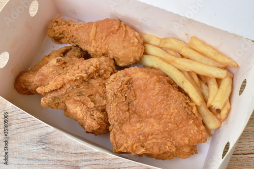 fried chicken and French fries in paper box packing on table