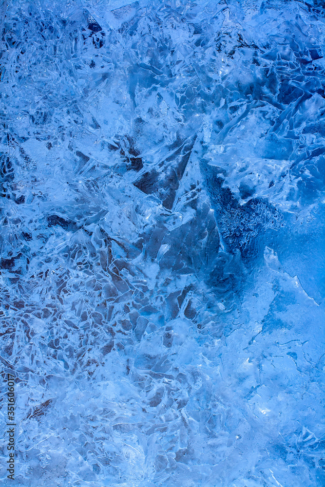 Amazing ice texture background. Blue ice lake with cracks and frozen air bubbles. Vertical.. Amazing ice texture background. Blue ice lake with cracks and frozen air bubbles. Vertical..