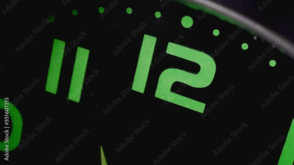 close up on twelve o'clock on the wall clock while the hands turning