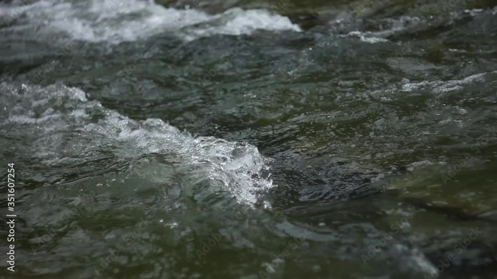 Close up small waves of river stream. Fast flow of water. Clear mountain river Close up small waves of river stream. Fast flow of water. Clear mountain river