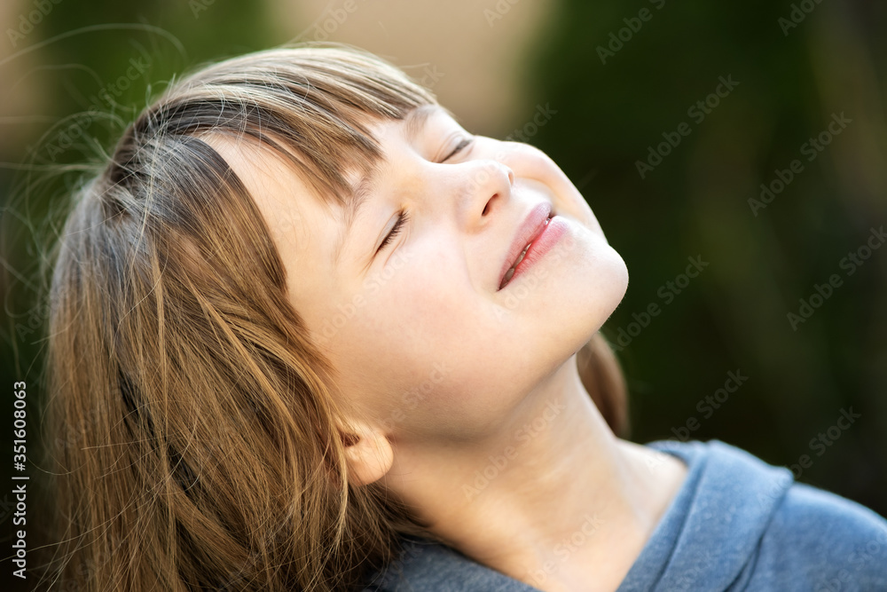 Portrait of young pretty child girl with long hair enjoying warm sunny day in summer outdoors. Cute female kid relaxing on fresh air outside. Portrait of young pretty child girl with long hair enjoying warm sunny day in summer outdoors. Cute female kid relaxing on fresh air outside.