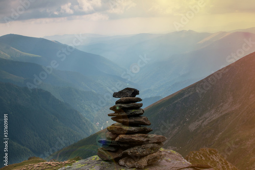 Balancing rock art. Stones balance on top of each other on a stone on top of a mountain. З Zen stones or a stack of zen against a background of blue mountains.
