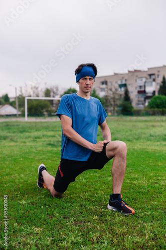 Athlete does warm-up before running at stadium © Denis