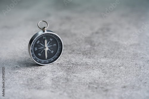 Old compass on stone floor background