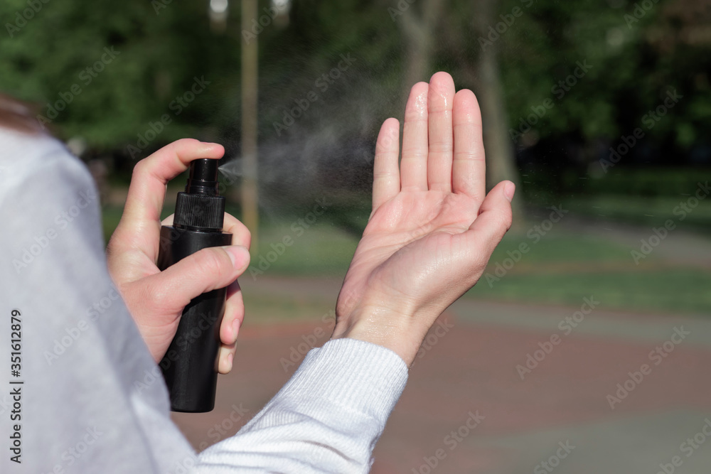 Spray antiseptic on hands close-up. Compliance with security measures. Girl in the Park. Hand in gel, spray freeze frame Spray antiseptic on hands close-up. Compliance with security measures. Girl in the Park. Hand in gel, spray freeze frame