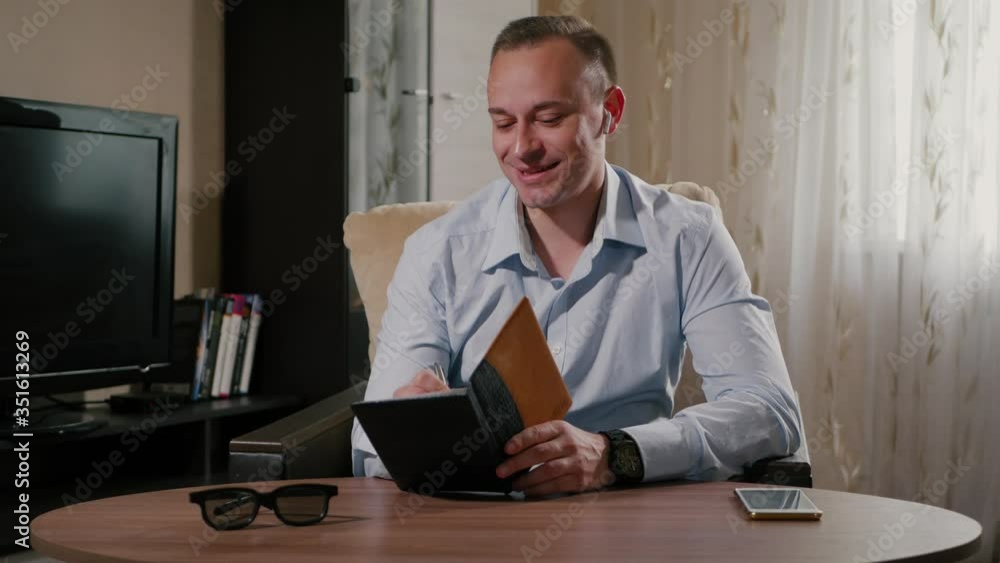 Freelancer talking in wireless headphones in home. Freelancer talking in wireless headphones in home.