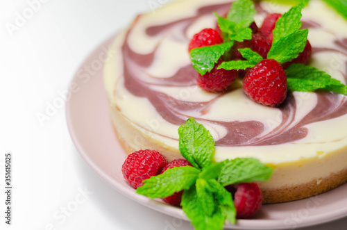 Creamy vanilla baked cheesecake, swirled with raspberry sauce on a biscuit crumb base