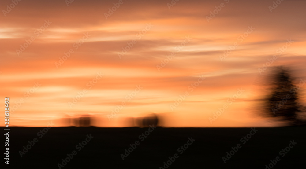 Blurry hay bales at sunset