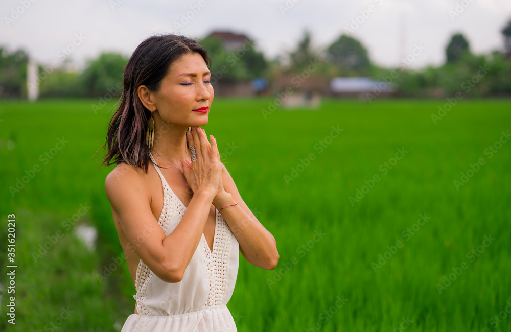 outdoors holidays portrait of attractive and happy middle aged Asian Korean woman in white dress enjoying freedom and nature at green field landscape carefree and cheerful outdoors holidays portrait of attractive and happy middle aged Asian Korean woman in white dress enjoying freedom and nature at green field landscape carefree and cheerful