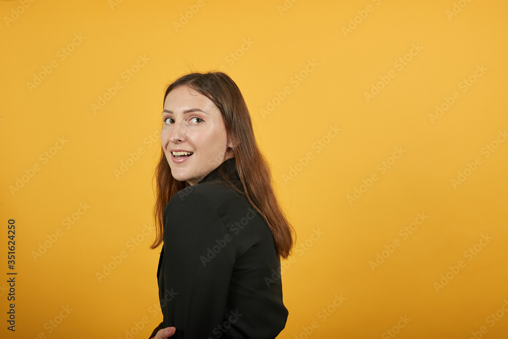 Young Attractive Brunette Woman In Black Stylish Suit, Red Shirt On Yellow Background, Surprised Girl Turned Sideways And Reacts To Surprise. The Concept Of Confused People Young Attractive Brunette Woman In Black Stylish Suit, Red Shirt On Yellow Background, Surprised Girl Turned Sideways And Reacts To Surprise. The Concept Of Confused People