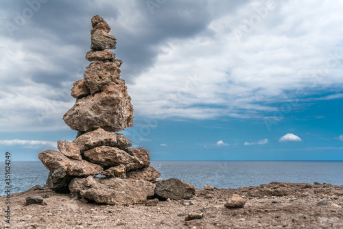 Steinmännchen vor wolkigem Himmel am Meer photo