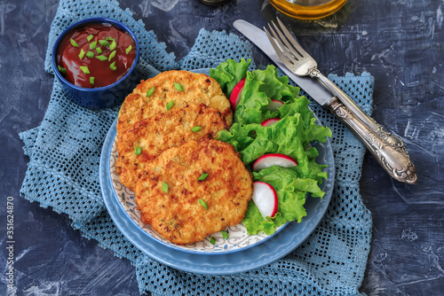 Pan fried chicken mince cutlets with spring onion lettuce radish and tomato sauce  on dark background