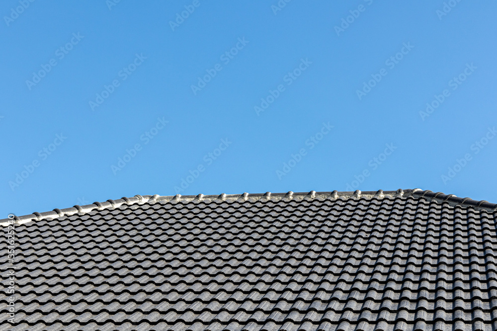Gray tile roof of construction house with blue sky. Gray tile roof of construction house with blue sky.