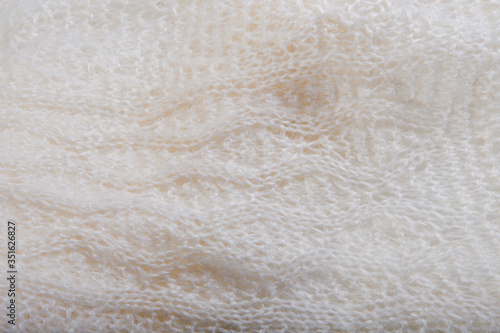 top view macro handmade openwork binding creamy, knitted, woolen scarf with pattern
