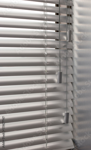 Aluminum blinds. Made from metal. Venetian blinds closeup on the window. Silver color. Closed horizontal blinds in sunny day. Modern sun protection and window decoration.