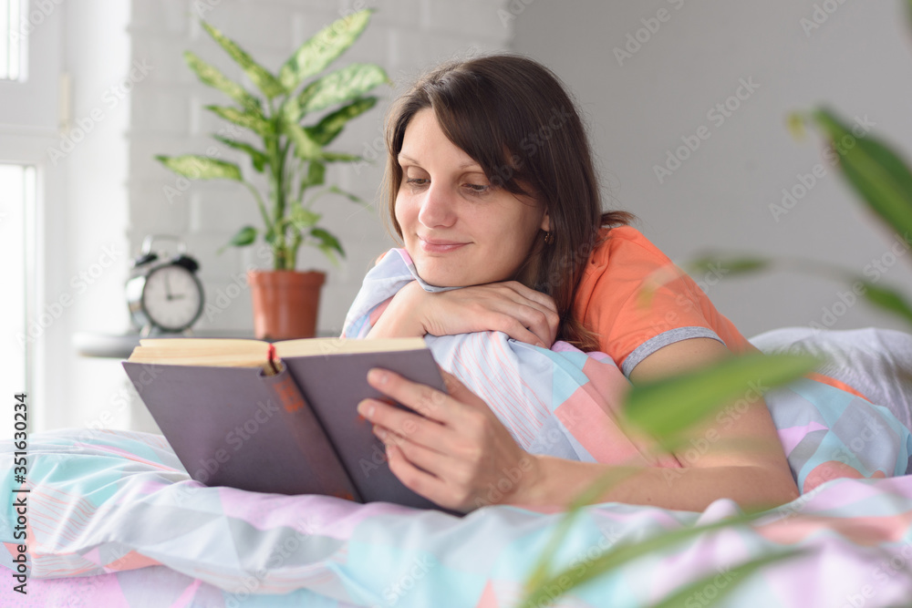 A girl at home waking up in the morning began to read her favorite book A girl at home waking up in the morning began to read her favorite book