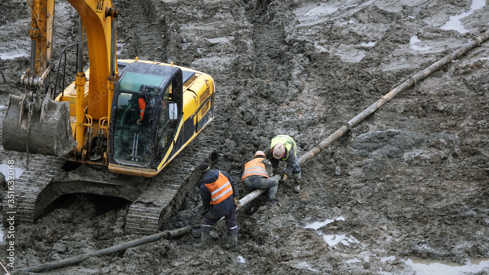 Workers and machinery - zero-cycle construction of the foundation of an entertainment center Workers and machinery - zero-cycle construction of the foundation of an entertainment center