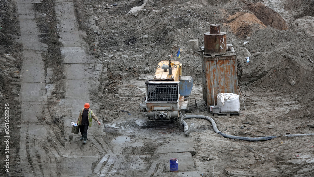 Fototapeta premium Workers and machinery - zero-cycle construction of the foundation of an entertainment center