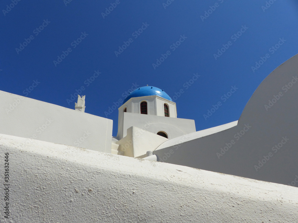 White architecture and blue domes in Oia, Santorini island, Thira, Cyclades islands, Greece.