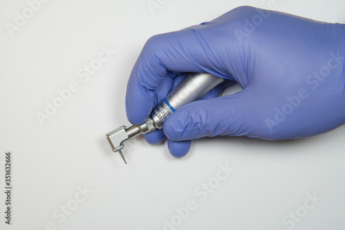 Dental tool, dentist tool, a hand in a medical glove holds a dentist tool. Quality photo on a white background