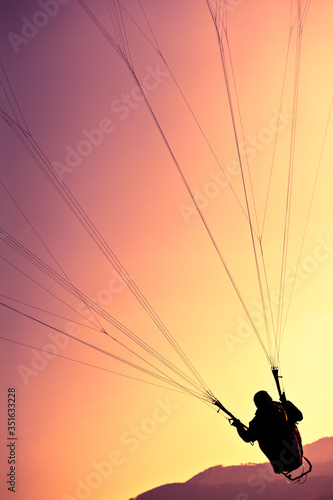 Paralotniarz latający o wschodzie słońca