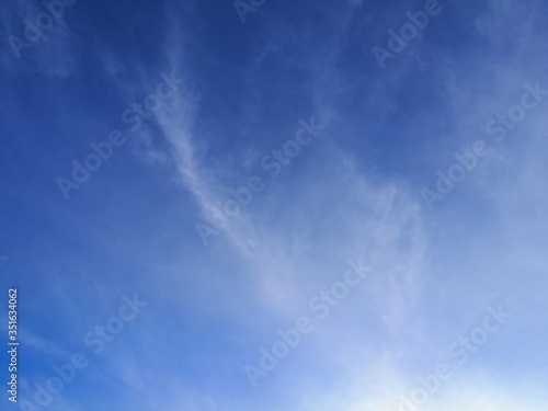 White cirrus clouds formations on blue sky, texture background