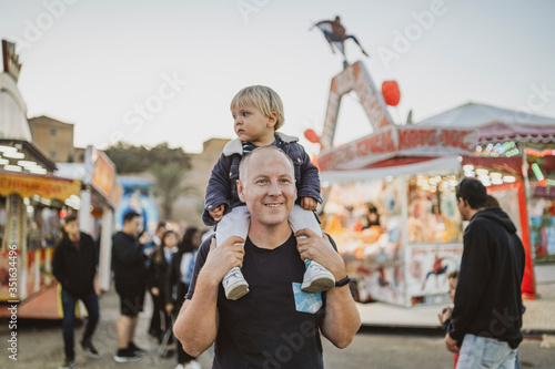 Happy father with his little son in an amusement park