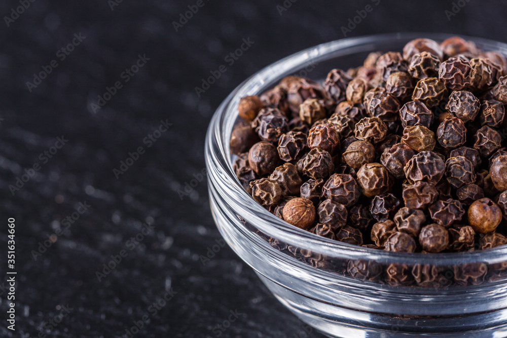 aromatic black pepper on a dark stone background aromatic black pepper on a dark stone background