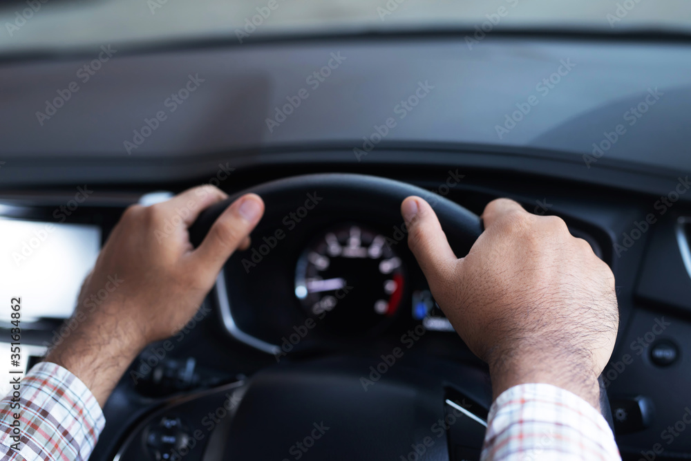 Close up of hand hold steering wheel young man driver a car riding on the road. trip of travel. vehicle transportation and safe driving concept. Close up of hand hold steering wheel young man driver a car riding on the road. trip of travel. vehicle transportation and safe driving concept.