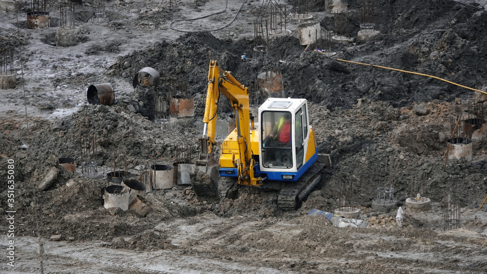 Tractors and excavators work on the construction of the foundation zero cycle Tractors and excavators work on the construction of the foundation zero cycle