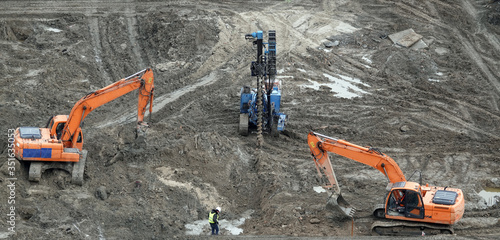 Tractors and excavators work on the construction of the foundation zero cycle