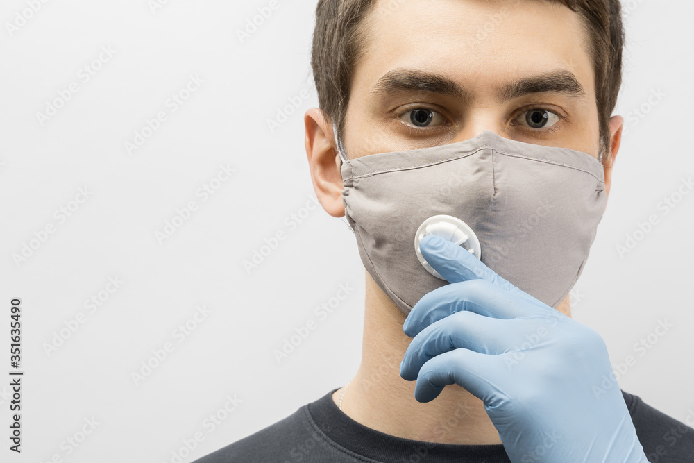 Young european man wearing mask against the corona virus and thumbs up covid 19 man wearing reusable surgical mask to prevent from virus white\grey background Corona virus pandemic funny fun Young european man wearing mask against the corona virus and thumbs up covid 19 man wearing reusable surgical mask to prevent from virus white\grey background Corona virus pandemic funny fun