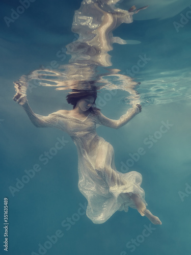 Portrait of a girl in a dress floating underwater