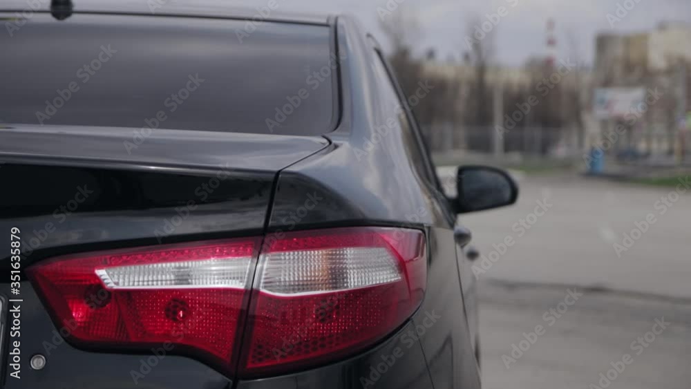 Rear brake lights on a black modern car. Trunk and red taillights Rear brake lights on a black modern car. Trunk and red taillights