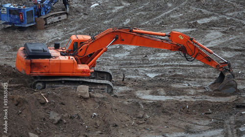 Tractors and excavators work on the construction of the foundation zero cycle