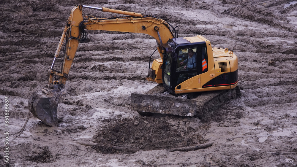 Workers in the mud of a construction site at the stage of excavation; construction of a supermarket AUCHAN Workers in the mud of a construction site at the stage of excavation; construction of a supermarket AUCHAN