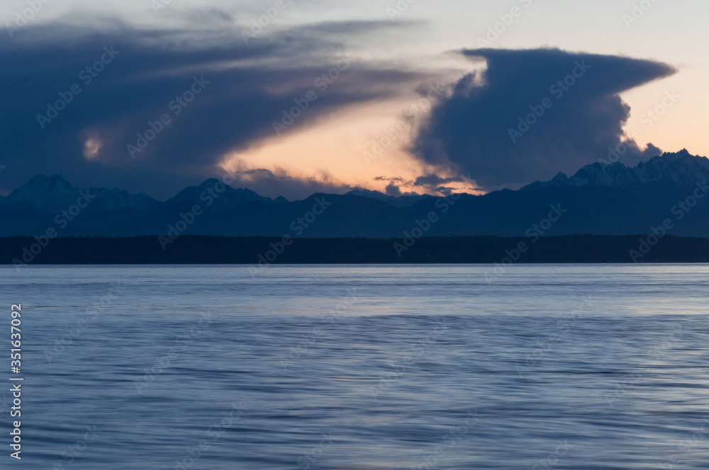 Closer long exposure shot of Olympic park mountains, evening sea and clouds in Picnic Point area, WA, USA