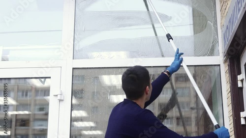 Wallpaper Mural a professional window cleaner soaps and squeegies a window clean, male cleaning worker. Torontodigital.ca